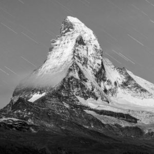 Pluie d'étoiles filantes sur le Mont Cervin  - Photo de montagne la nuit en noir et blanc sur un sommet rocheux  enneigé