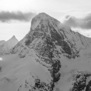 Dent Blanche - Black and white photo of the top of a rocky mountain massif and a mountain bivouac in the Valais Alps