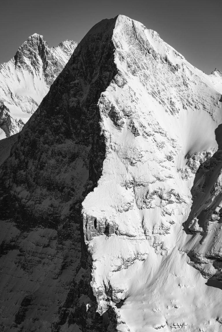 black and white snowy mountain Image   - Peak of The Eiger mountain  in shadow and light - The Eiger north and west face