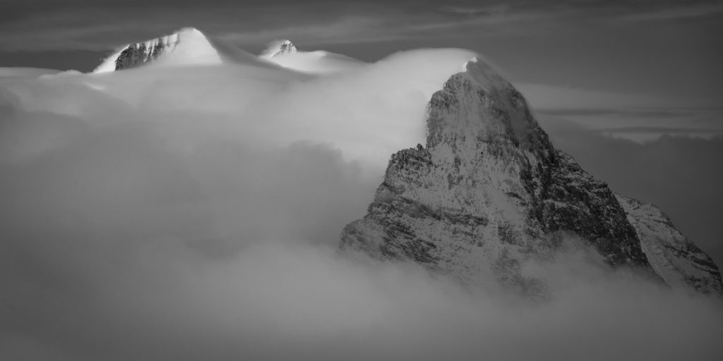 Eiger - Monch - Jungfrau - massif montagneux des somemts des Alpes en noir et blanc - arrête Mittellegi dans la brume