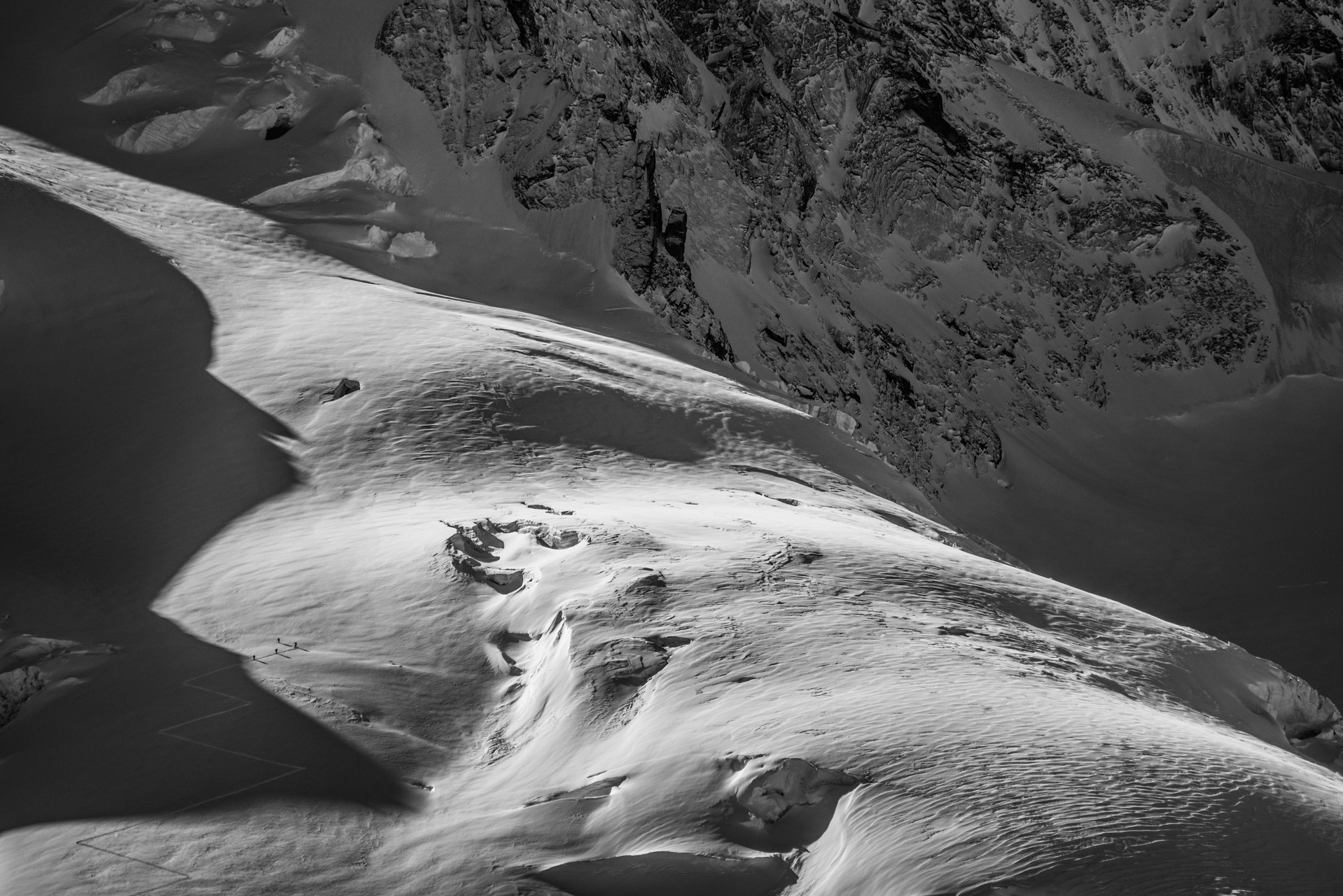 black and white Mountaineering photo with mountaineers in a glacier Valaisan Alps of Zermatt - Dufourspitze - Pointe Dufour