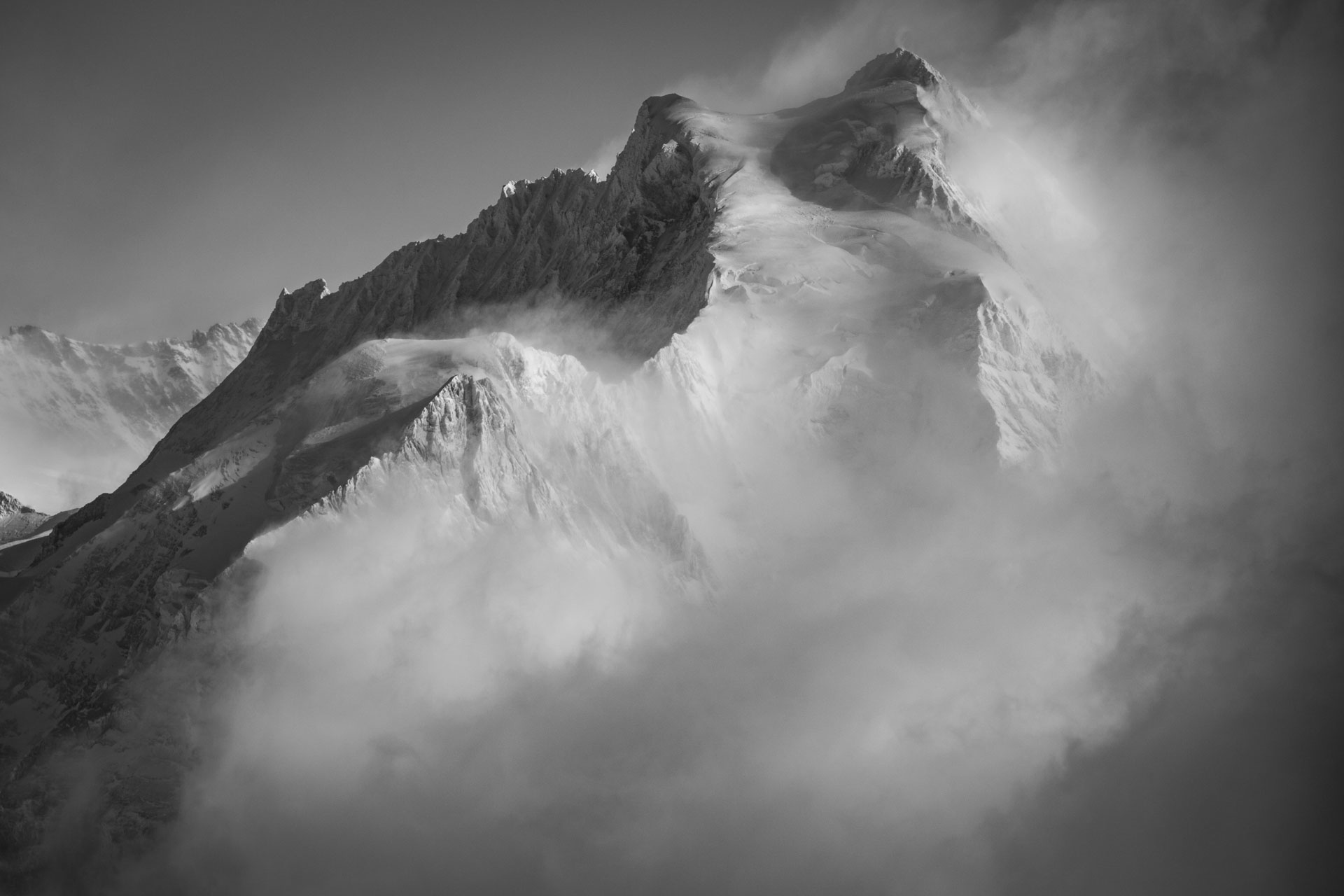 Jungfrau- black and white picture of Bernese alps pieak and mountain massif in a sea of clouds