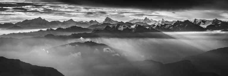 Bergpanorama der Walliser Alpen und Dents du midi schwarz-weiss - Fotoleinwand zum Einrahmen von Zermatt in einem Wolkenmeer unter Sonnenstrahlen