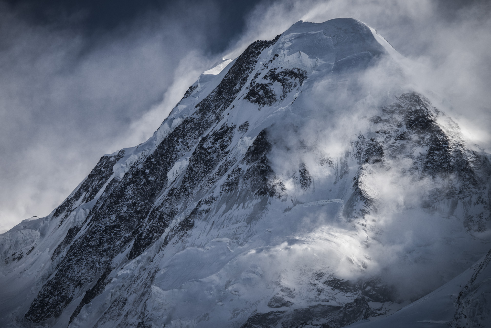 Sommet du Lyskamm dans une mer de nuage - Image de montagne rocheuse enneigée en hiver dans les Alpes Valaisannes à Zermatt
