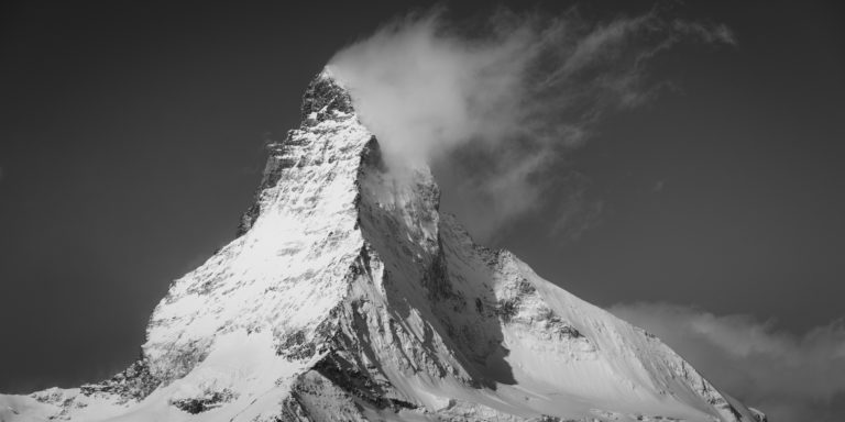 Matterhorn - Panorama d'un sommet de montagne sous la neige qui fume dans une mer de nuage
