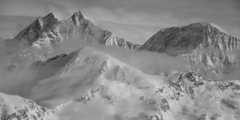 Panorama of a snowy mountain fog image in the Swiss Valaisan Alps from Zermatt - Saas Fee and dom des Mischabels