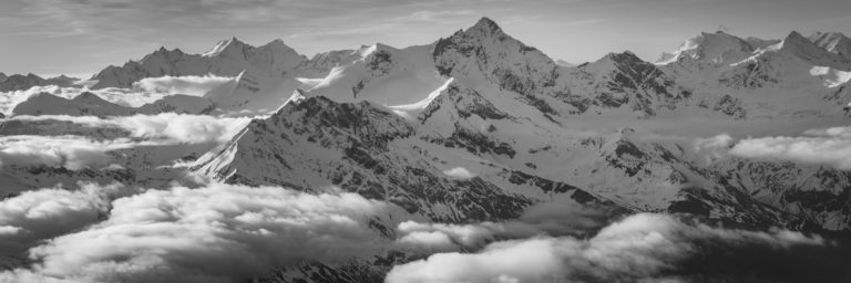 Schweizer Alpenpanorama in Schwarz-Weiß zum Einrahmen - Wolkenmeer über den schneebedeckten Gipfeln des Val d&#039;Anniviers und Saas-Fee