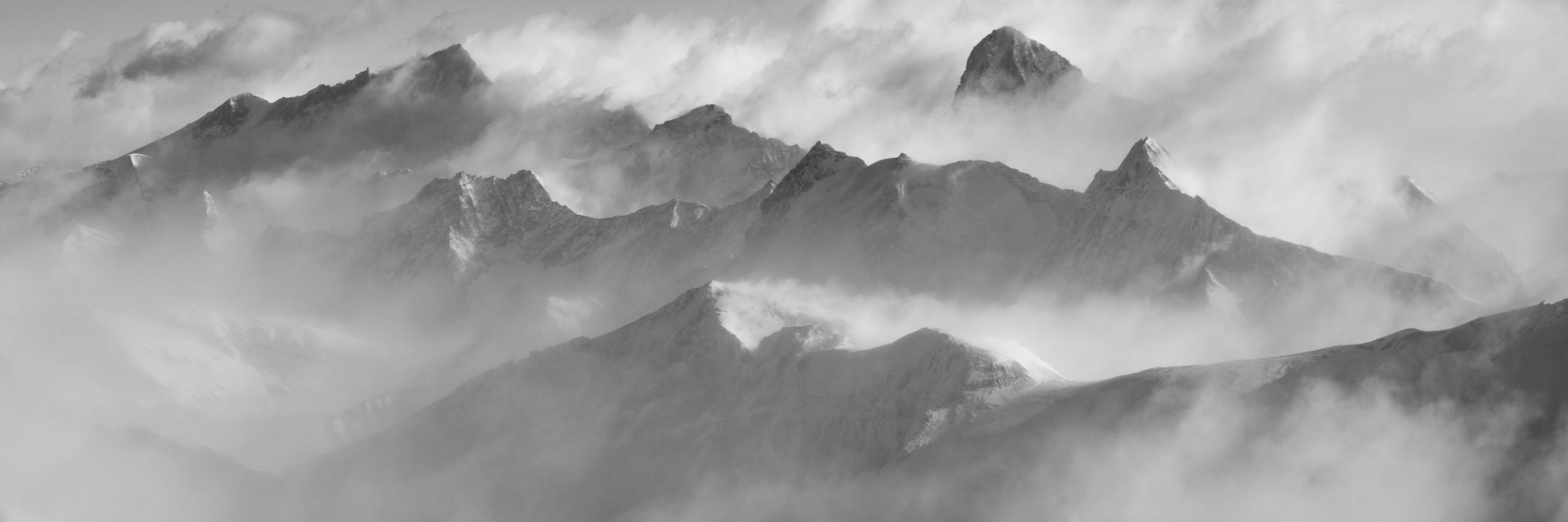 Black and white Panorama of the mountain peaks of the Valais Alps under a sea of ​​clouds - Crans Montana - Arolla- Dent Blanche - Val d'Hérens