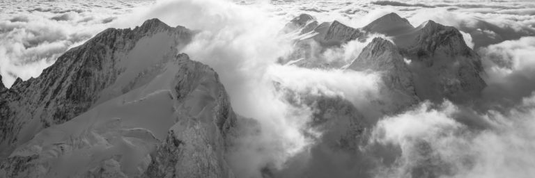 Black and white mountain panorama of the Bernina Massif - Sea of clouds in the mountain summit of the Swiss Engadin Alps