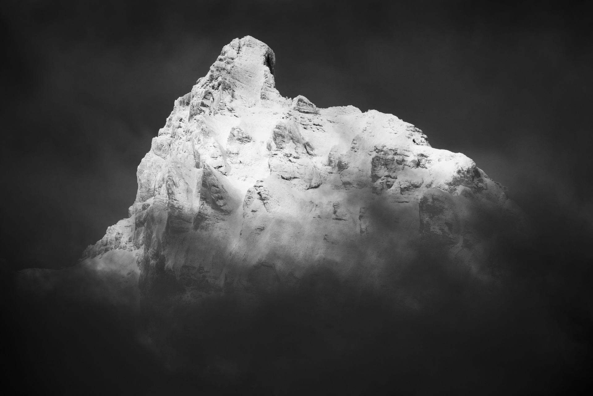 Le petit Muveran - sommet de montagne d'Ovronnaz noir et blanc dans une mer de brume et de nuages