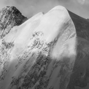 Schwarz-Weiß-Fotografie des Piz Roseg, der eine perfekte Kurve bildet, seine hängenden Gletscher enthüllt und die zerbrechliche Schönheit der Schweizer Alpen illustriert.