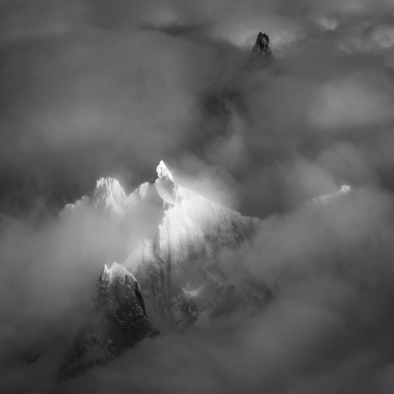 Mont-Blanc-Massiv Chamonix in Schwarz-Weiß -Gipfel der Berge Aiguille du Plan und Dent du Géant in einem Meer aus Wolken und Dunst Nebel