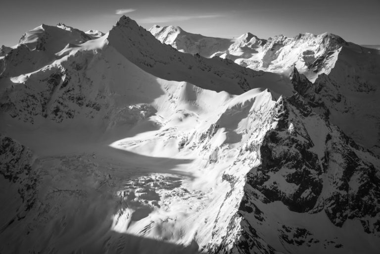 Zinalrothorn - Snowy mountain landscape under the rays of the sun illuminating the rocky mountain of Switzerland towards Crans Montana