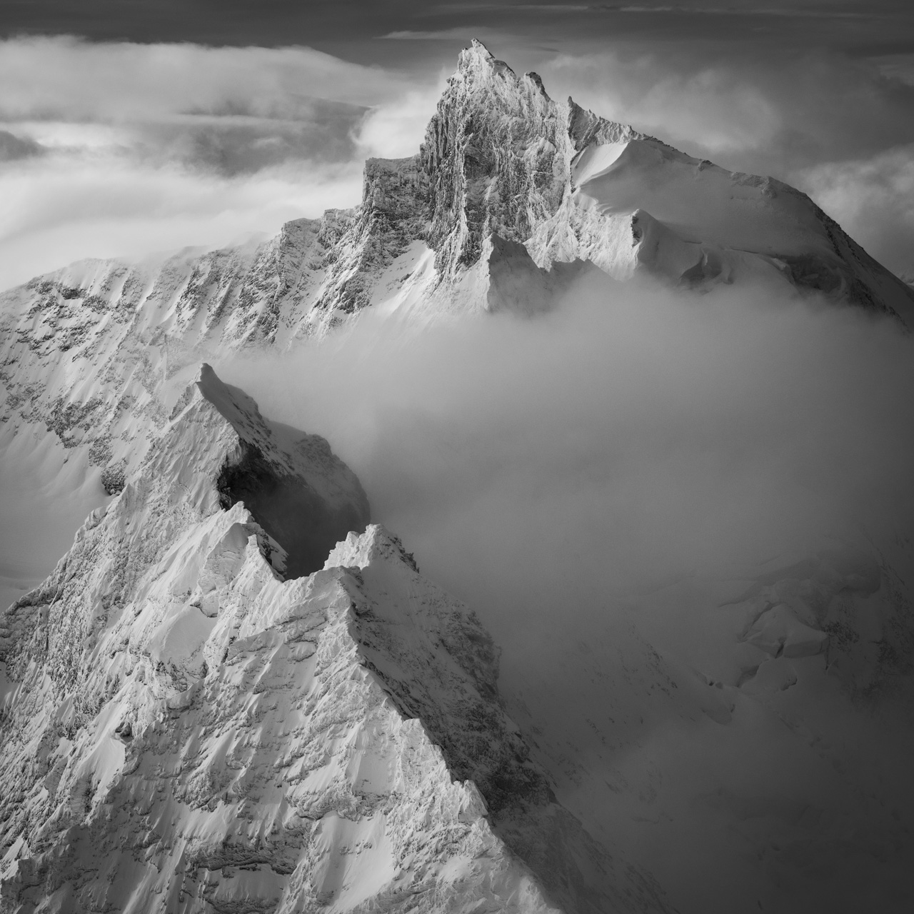 black and white alpine mountain picture in a sea of clouds