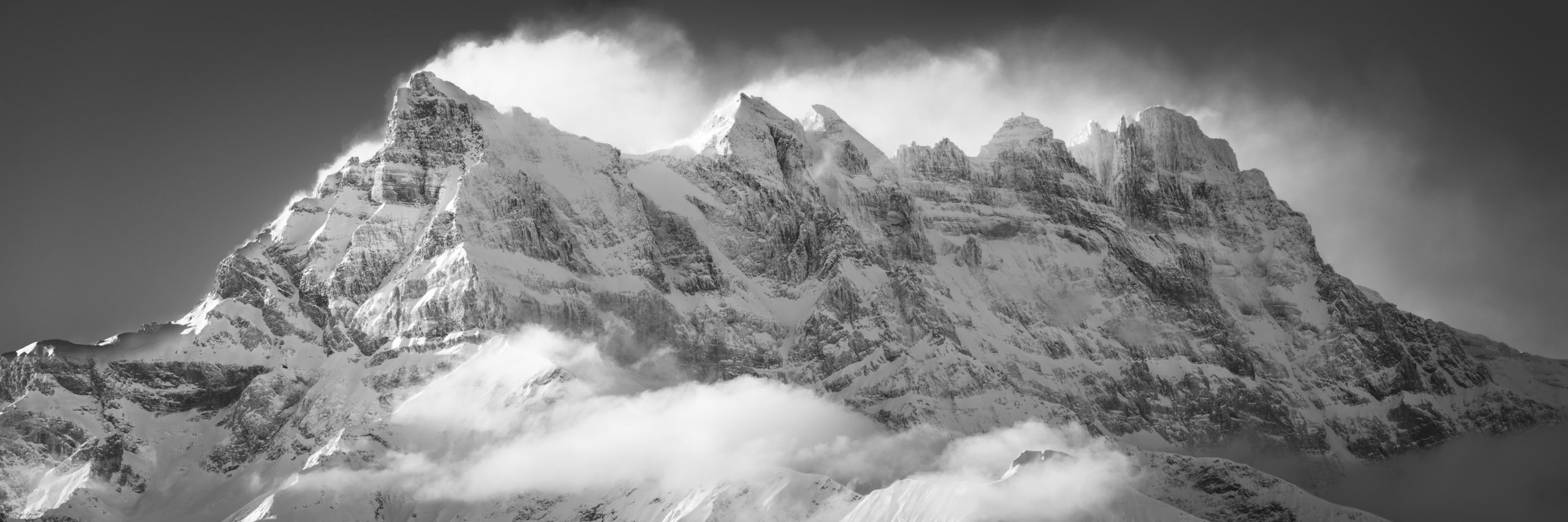 Schwarz-Weiß-Panorama der schneebedeckten Berge von The Dent Blanche während eines Sonnenaufgangs auf diesem Massiv der Alpen in der Schweiz