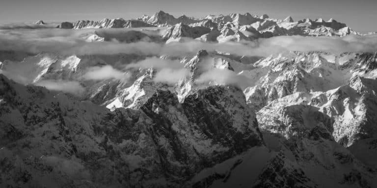 Panoramafoto von Gross Windgällen und den Berner Alpen - Panorama auf die aus dem Nebel auftauchenden Berner Alpen mit Gross Windgällen im Vordergrund.