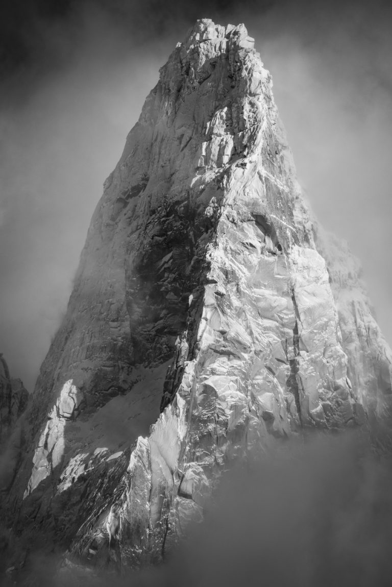 Black and white photo of the Drus Chamonix - summit of the Drus after a snowstorm coming out of the sea of clouds