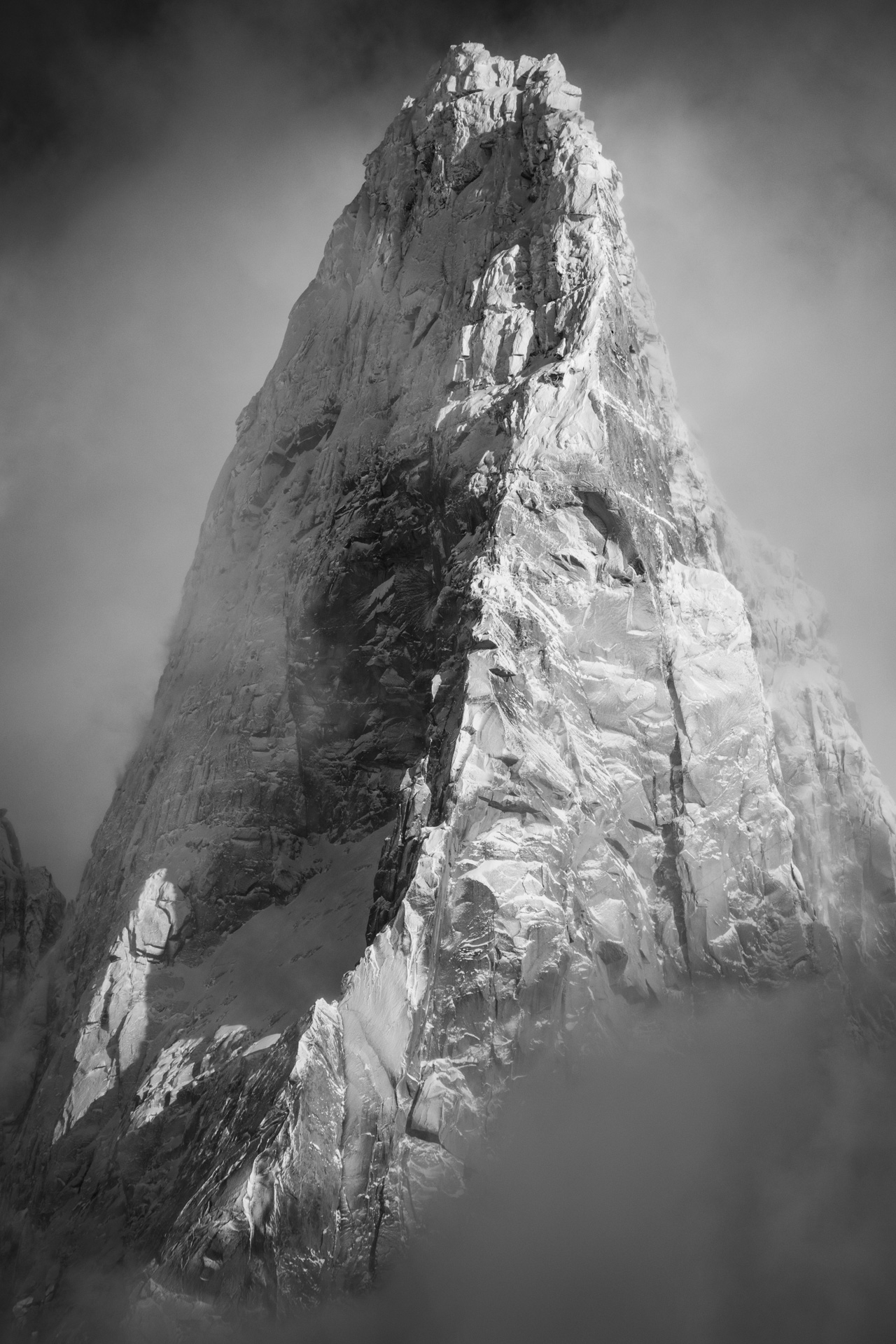 Photo noir et blanc des Drus Chamonix - Sommet des Drus après une tempète de neige qui sort de la mer de nuages