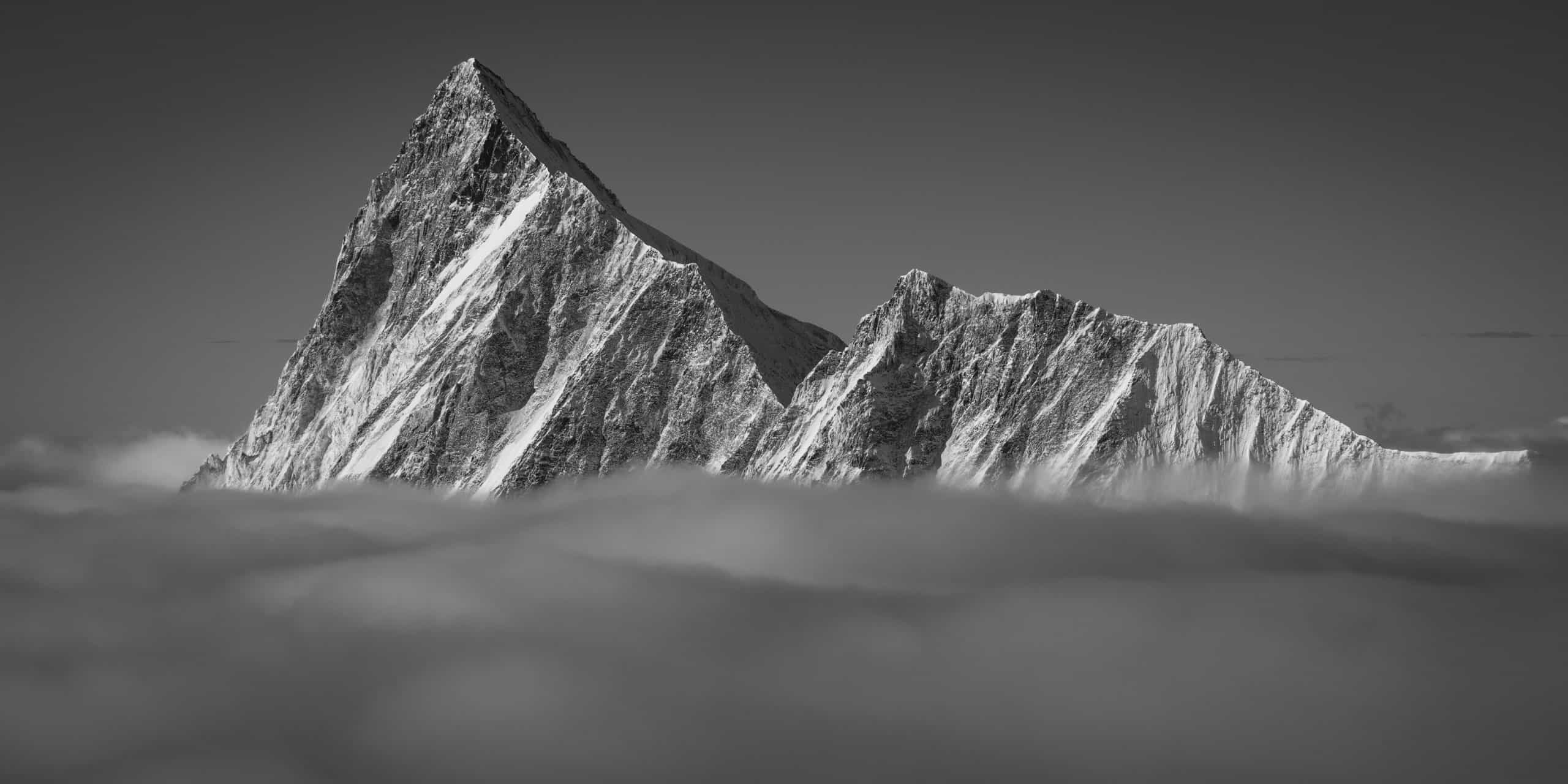 Panoramic photo of the Finsteraarhorn and the Agassizhorn. The summit of the Finsteraarhorn emerges from the sea of clouds after a period of snow.