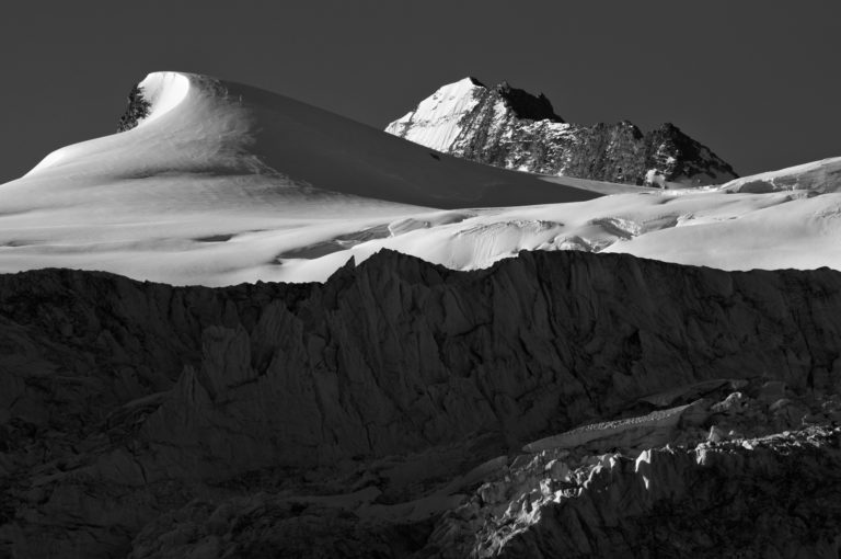 Photo des montagnes au-dessus de Moiry. Vue sur le sommet des Bouquetins et sur le Grand Cornier. Empilement des strates des séracs et du glacier menant notre regard sur les hauts sommets enneigés.