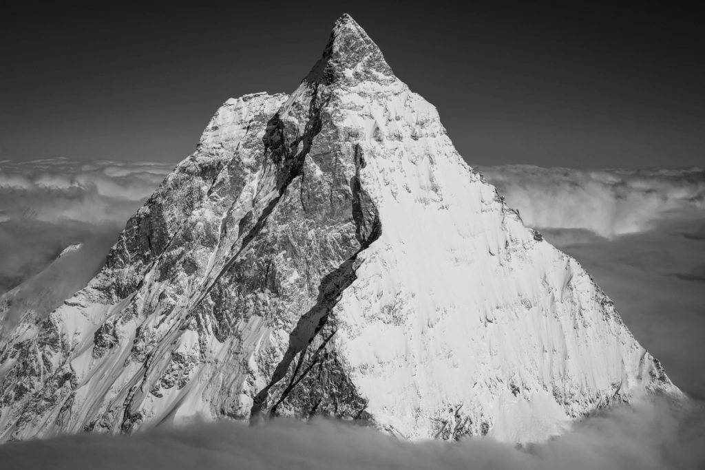 Photo en noir et blanc du Matterhorn au-dessus de la mer de nuages