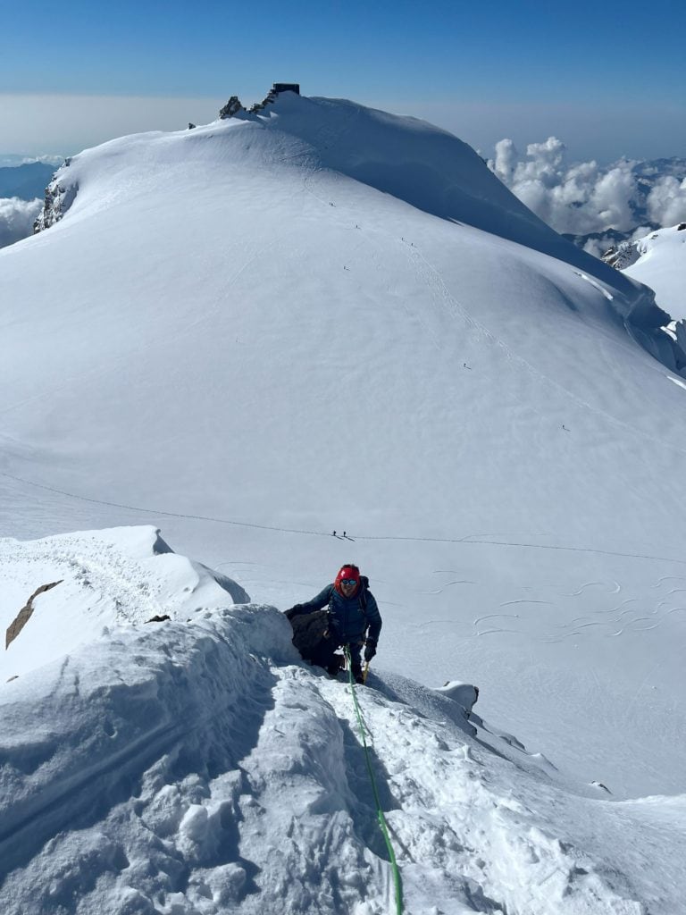 Alpiniste arrivant au sommet de la Zumsteinspitze avec la Pointe Gnifetti en arrière plan