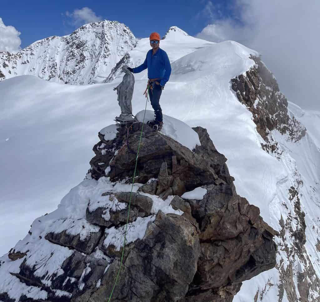 Alpiniste à côté de la vierge du Corno Nero