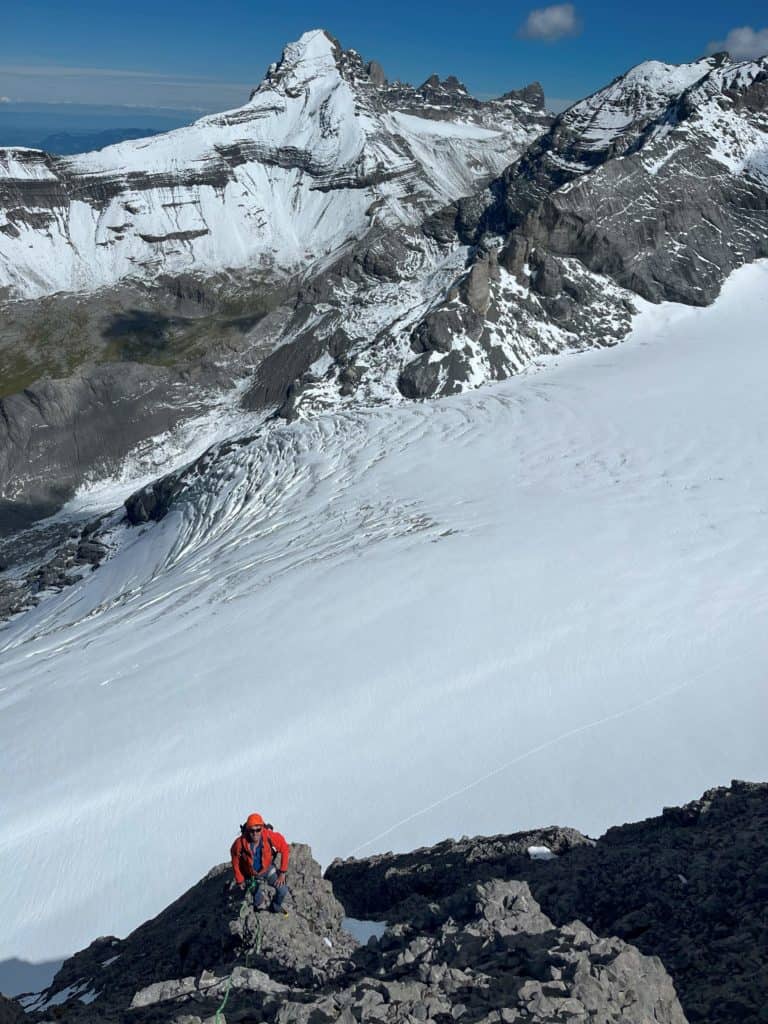 Alpiniste en train de tenter l'ascension du mont Ruan. Vue sur les Dents du midi en arrière plan