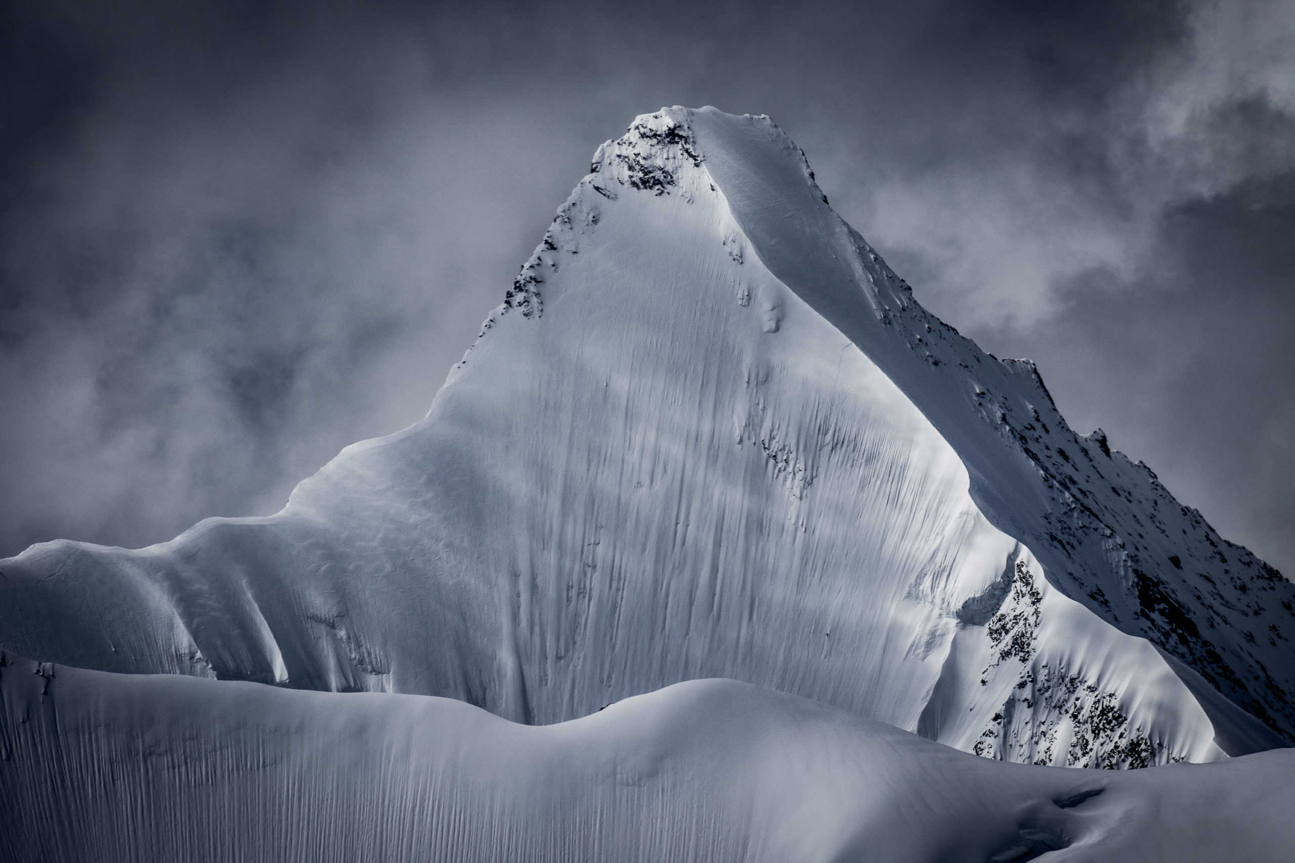 Fotografie der Nordwand desObergabelhorn. Eine der mythischsten Wände der Alpen und eine der schönsten! Frisch verschneit und mit einem besonderen Lichtspiel erscheint dieObergabelhorn in ihrer reinsten Form.
