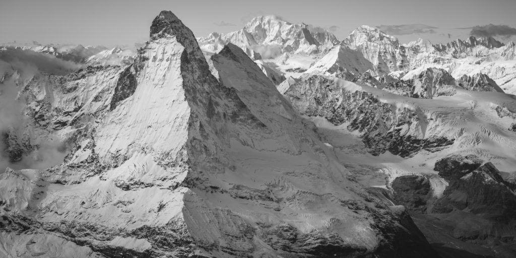 Schwarz-weiße Panoramafotografie des Matterhorns und der umliegenden Gipfel.