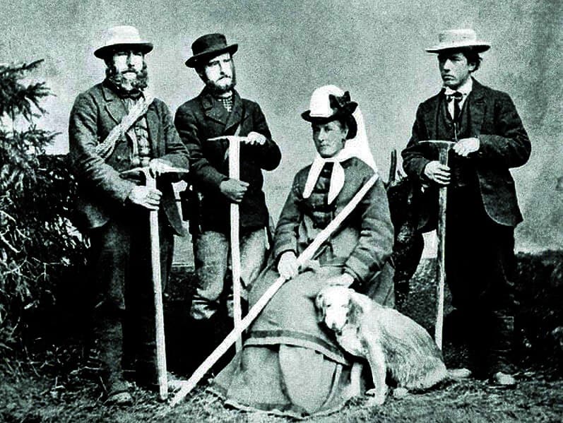 Photo en noir et blanc de Margaret Claudia Brevoort et son chien avec trois hommes tenant un piolet derrière elle