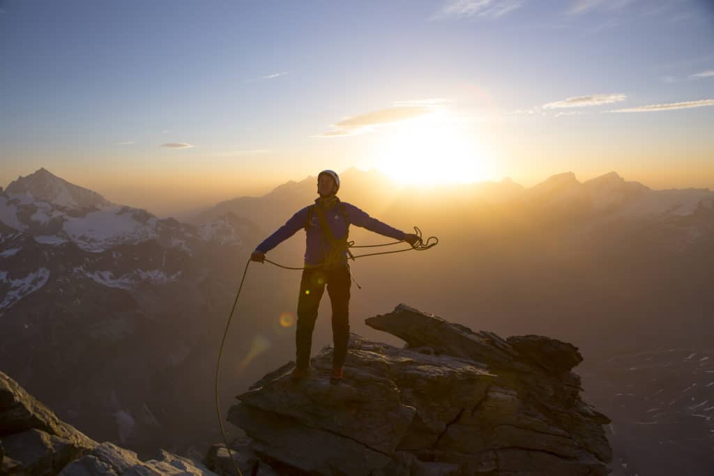 Alpiniste au sommet du Cervin dos au coucher de soleil