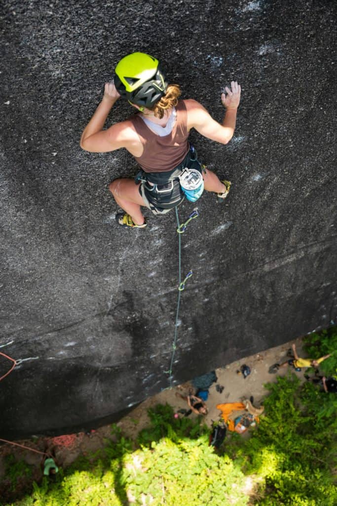 Femme en train de grimper en tête sur un mur de couenne