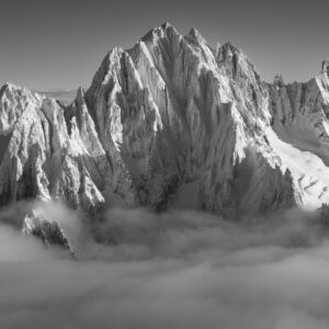 Aiguille Verte and Alpine summits emerging from a sea of clouds at sunrise in black and white
