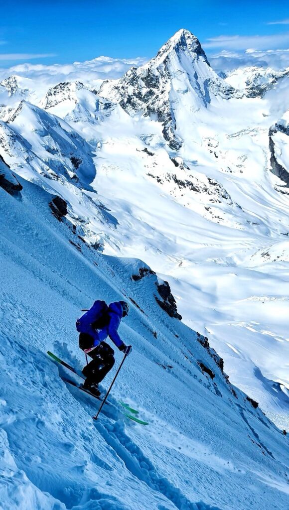 Gilles Sierro skiing down the Zinalrothorn against the spectacular backdrop of the Valais Alps.