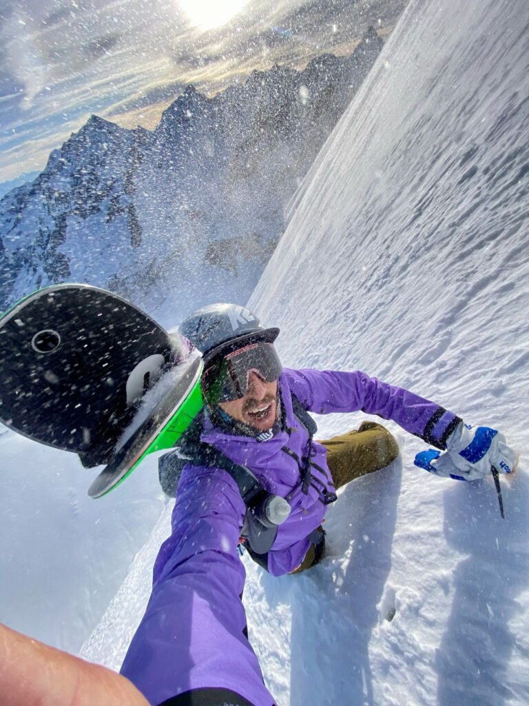 Gilles Sierro climbing the north face of Dent Blanche Blanche, skis on his back and snow blowing.