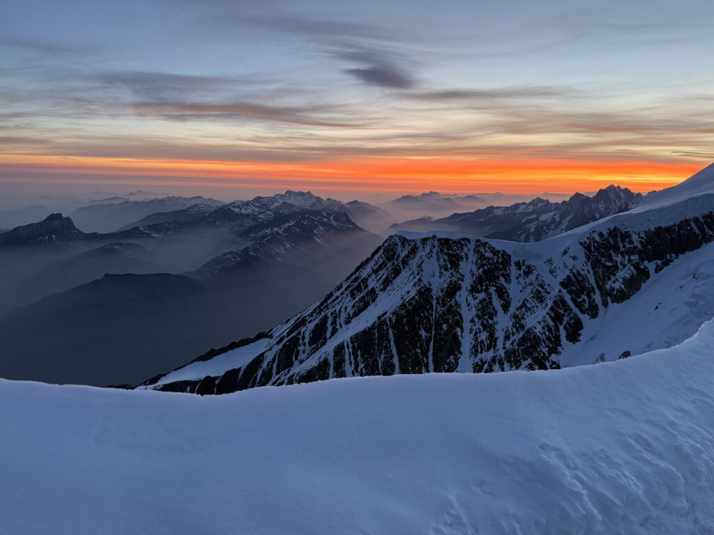 Lever de soleil enneigé sur l'arrête de l'Aiguille de Bionnassay au Dôme du Rocher Snow-covered sunrise over the Aiguille de Bionnassay ridge at Dôme du Rocher