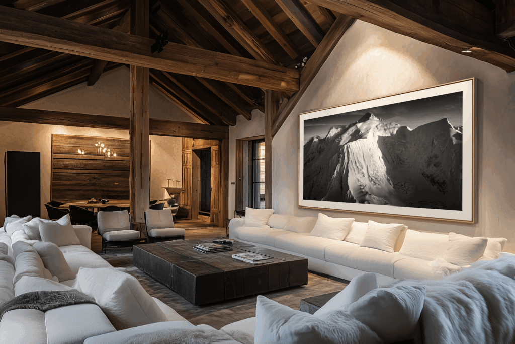 In this alpine chalet, black-and-white mountain photography elegantly enhances the space. The combination of raw wood, contemporary furniture and wall art creates a warm, refined atmosphere, perfect for modern chalet decor.