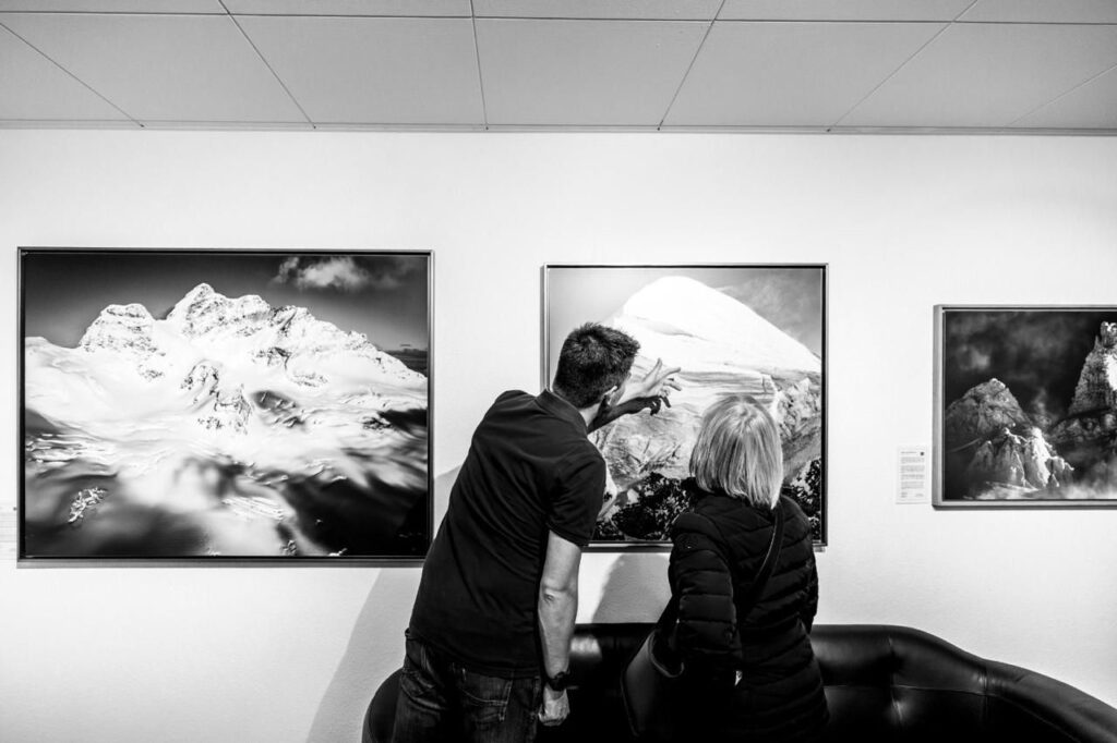 Der Fotograf erklärt einer Dame eines seiner Werke innerhalb einer Fotoausstellung